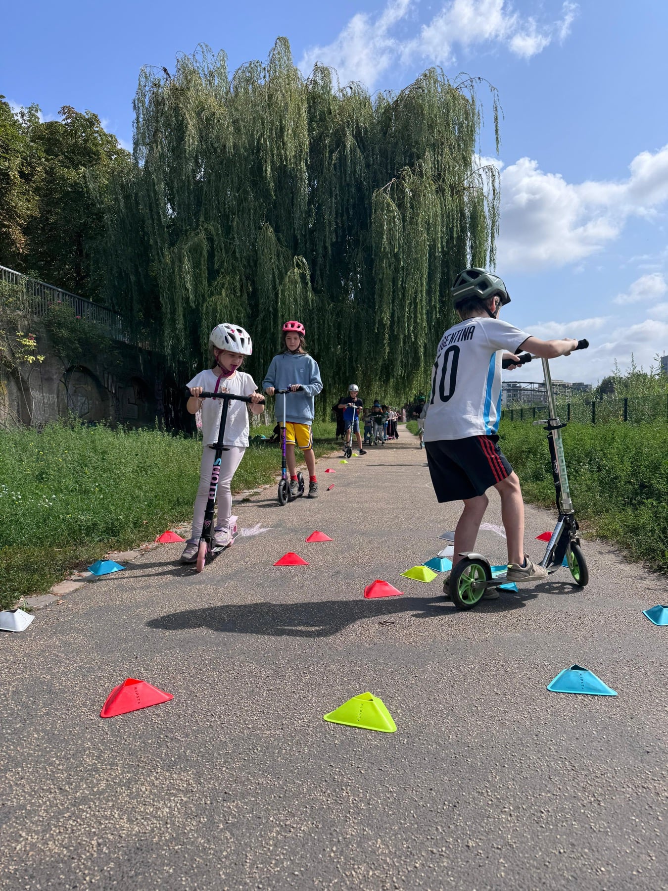 Kinder fahren im Feriencamp einen Rollerparcours